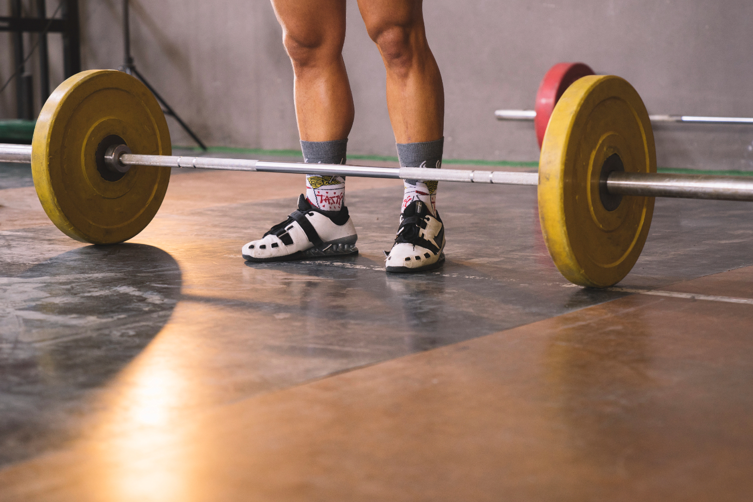 deportista en un gimnasio con una barra olímpica para hacer peso muerto sumo